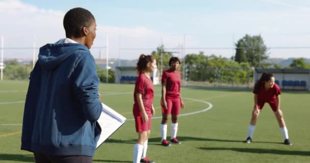 Treinadora feminina com equipe de futebol durante a prática no futebol fied — Vídeo de Stock