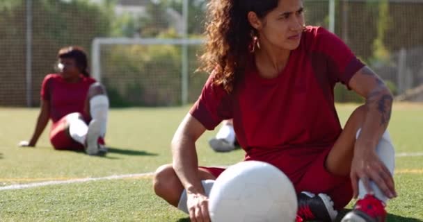 Female soccer player sitting on field relaxing with team — Stock Video