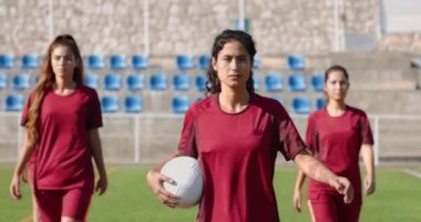 Bir grup kendine güvenen bayan futbolcu maçtan önce yürüyor