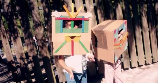 Дві маленькі дівчата, одягнені як роботи, розважаються в саду — стокове відео