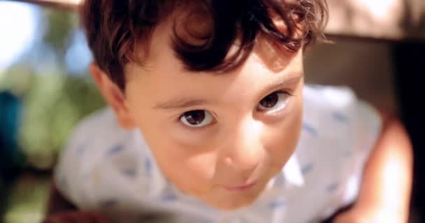 Söt liten pojke ler och tittar på kameran — Stockvideo