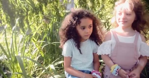 Twee kleine schattige meisjes staan samen in een tuin — Stockvideo