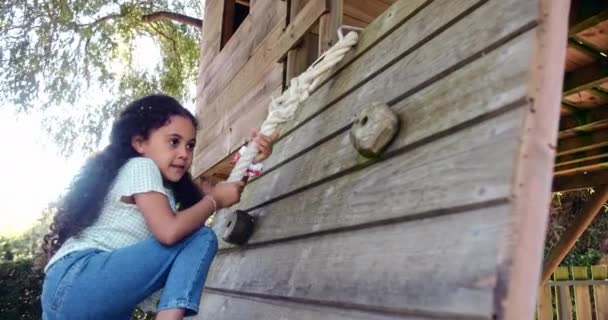 Little girl playing and climbing rope in a tree house — Stock Video