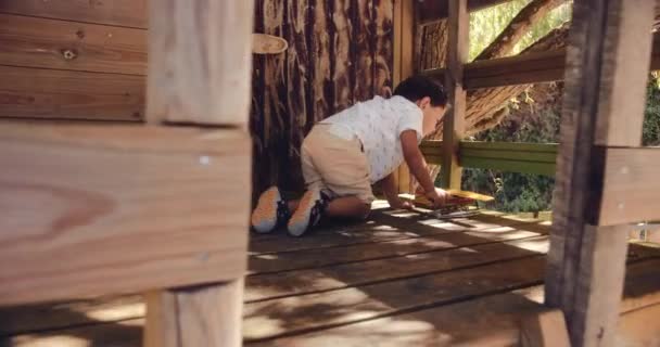 Menino brincando com brinquedo de avião vintage na casa da árvore — Vídeo de Stock