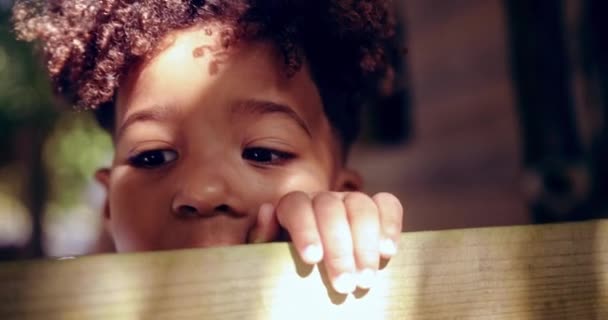Gros plan d'un petit garçon afro-américain cachant son visage en train de jeter un coup d'œil — Video