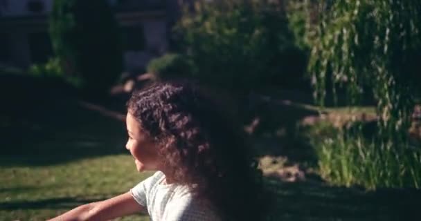 Menina correndo no jardim brincando com bola explosiva — Vídeo de Stock