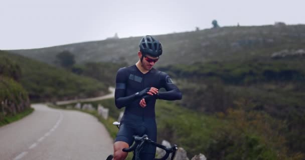 专业自行车手在山上检查自行车上的健身跟踪器 — 图库视频影像