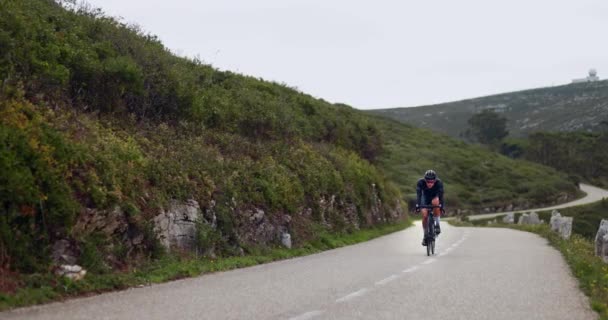 Professionele fietser fietsen snel bergop de berg — Stockvideo