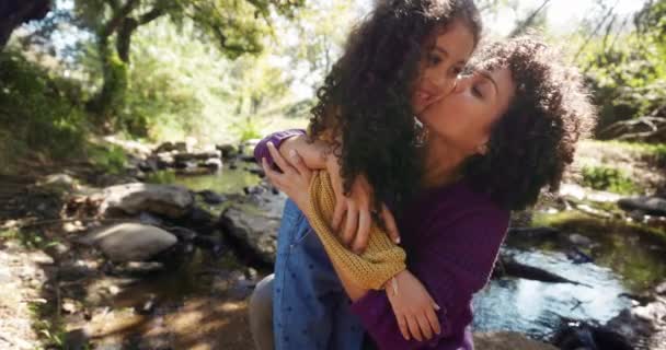 Madre abrazando y besando hija al aire libre por el río — Vídeos de Stock