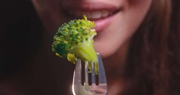 Молода жінка рот їсть брокколі — стокове відео