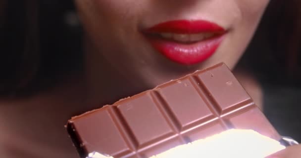 Jonge vrouw mond bijten chocolade bar — Stockvideo