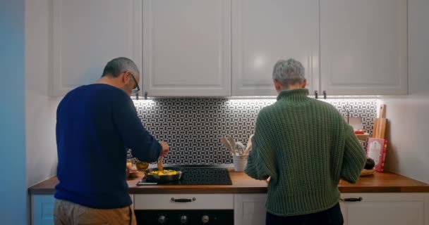 Старша пара готує їжу разом на кухні — стокове відео