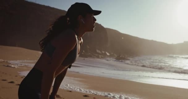 在海滩上跑步后，有耳塞的妇女休息 — 图库视频影像