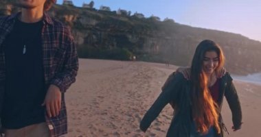 Sahilde sırtında taşıdığı için arkadaşlarının üstüne atlayan bir kız.