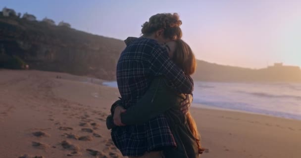 Young couple hugging at the beach during sunset — Stock Video