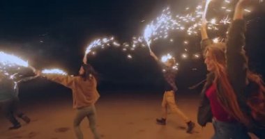 Kumsalda maytaplarla koşan gençler