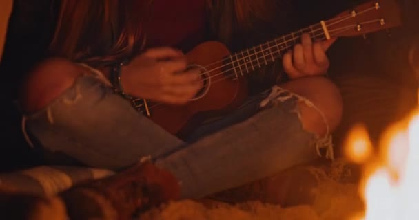 Chica jugando ukelele en hoguera de playa en la noche — Vídeos de Stock