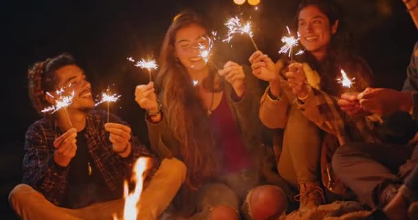 Grupo de amigos comemorando com faíscas na fogueira da praia — Vídeo de Stock