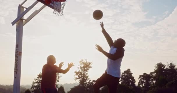Двоє щасливих літніх чоловіків грають у баскетбол на відкритому повітрі — стокове відео
