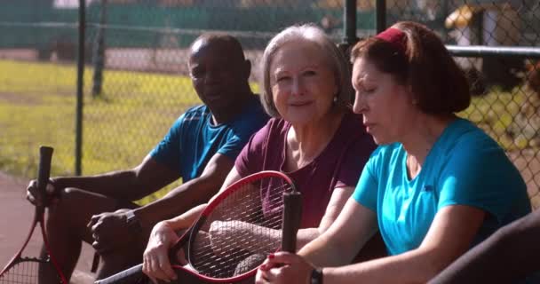 Seniorengruppe ruht sich nach Tennisspiel aus — Stockvideo