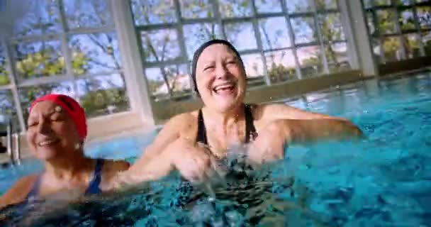 Egy csapat boldog nyugdíjas, akik vizet fröcskölnek a kamerába. — Stock videók