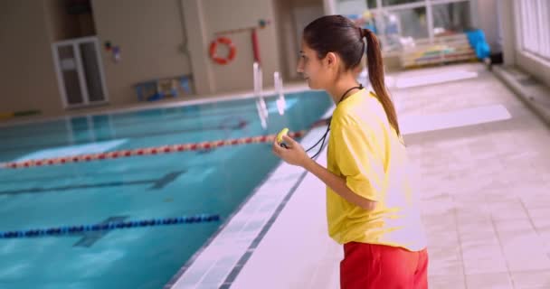 Gestos braço salva-vidas e soprando assobio na piscina interior — Vídeo de Stock