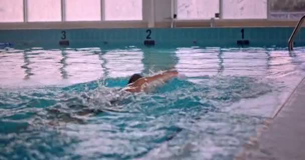 Profesionální amputovaný sportovec plavající ve vnitřním bazénu — Stock video