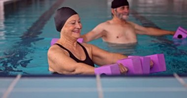 Üst düzey kadın aerobik sınıfında kollarını hareket ettiriyor.