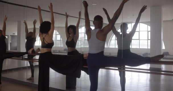 Učitel a studenti protáhnout nohu na tyči v tanečním studiu — Stock video
