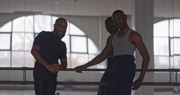 Два африканско-американских мужчины, которые позируют держа Барра на танцевальной студии — стоковое видео