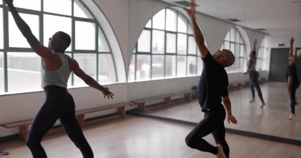 Two male ballet dancers spinning together in studio — Stock Video