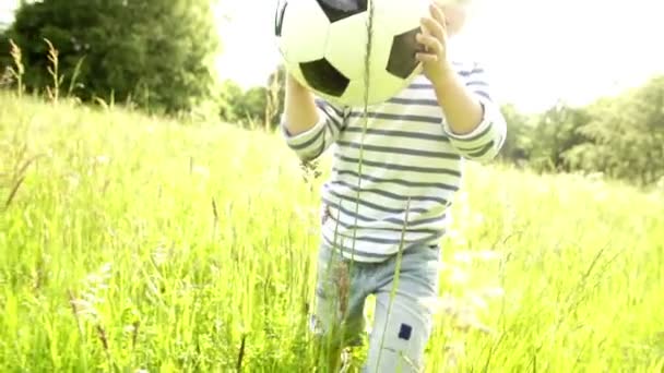 Kleiner Junge rennt mit Fußball — Stockvideo