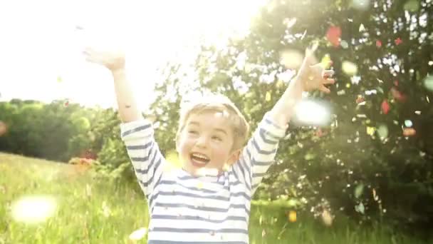 Pequeño niño lanzando confeti — Vídeo de stock