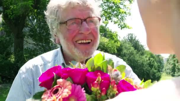 Boldog idősebb férfi ad virágok — Stock videók