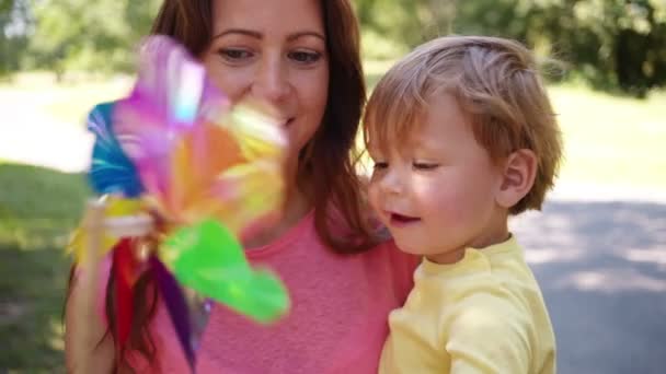 Moeder en zoon spelen met pinwheel — Stockvideo