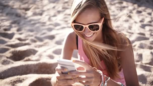 Chica mensajes de texto en la playa — Vídeos de Stock