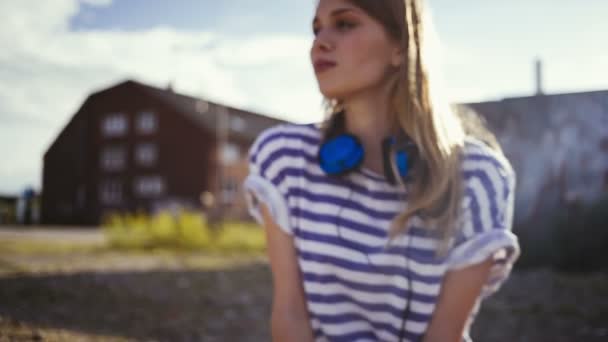 Adolescente chica sentada con auriculares — Vídeo de stock