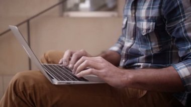 dizüstü bilgisayarda klavyede yazan adam