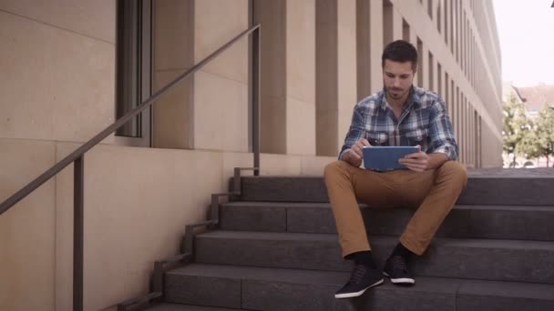 Людина зовні на сходах використовує планшет — стокове відео
