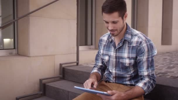 Hombre joven utiliza tableta — Vídeo de stock