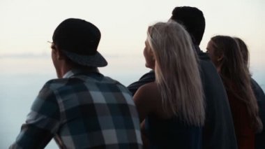 Birlikte gün batımını izlemek oturan gençler