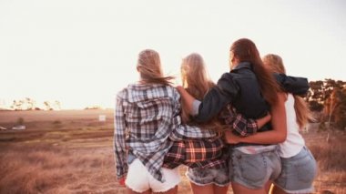 Genç kız gün batımına karşı karşıya