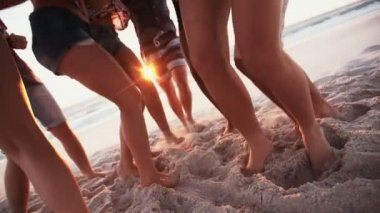 Arkadaş sahilde dans edenlerin bacaklarını