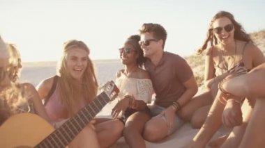 Bir gitar ile bir gün batımı beachparty arkadaşlar