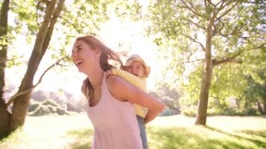 Parkta yürümeye başlayan çocuk kızı piggybacking anne