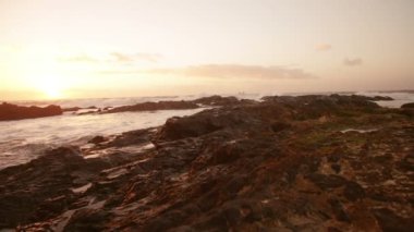 Gün batımında sahilde kayalar