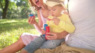 Baloncuklar bir parkta üfleme aile