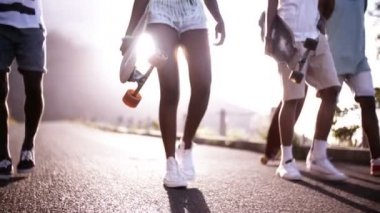 Amerikalı genç longboarders bir yolda yürürken