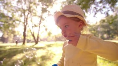 Küçük kız bir parkta kabarcıklar üfleme