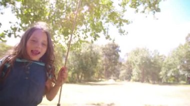 Güneşli parkta sallanan çocuk